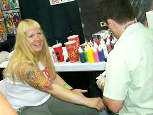 Blonde woman getting tattooed